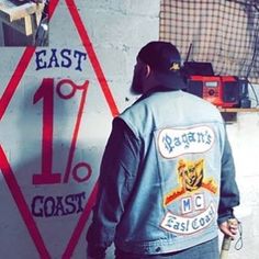 a man standing in front of a sign that says east coast 10 / 1 and has his back to the camera