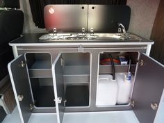 an rv kitchen with sink and cabinets in it