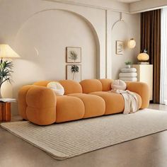 an orange couch sitting on top of a rug in a living room