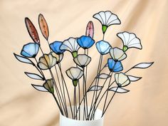 a vase filled with stained glass flowers on top of a table