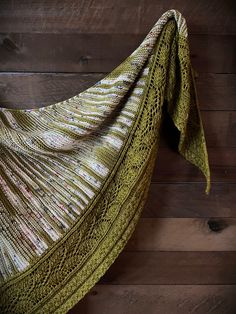 a green shawl hanging on a wooden wall