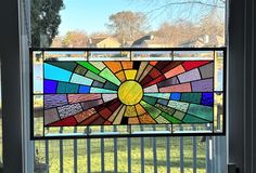 a stained glass window with a sunburst in the center on a sunny day