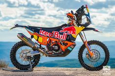 a red bull dirt bike parked on top of a hill