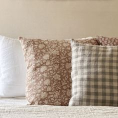 three pillows on top of a bed next to each other