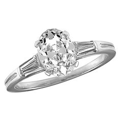 Sparkling oval brilliant cut engagement ring. Made and signed by TIFFANY & CO. The center stone is 1.20 cts. H-I color, VS1, very good symmetry, no fluorescence. One tapered diamond baguette on each side. Size 6 1/2 and can be custom-sized. Set in platinum. A fiery brilliant ring. Alice Kwartler has sold the finest antique gold and diamond jewelry and silver for over 40 years. Gia Certified Oval White Wedding Rings, Classic Oval Diamond Ring With Vvs Clarity, Oval Solitaire Diamond Ring In Platinum, Classic Oval Diamond Ring With Center Stone, Classic Oval Ring With Center Stone, Classic Oval Center Stone Wedding Ring, Oval Brilliant Cut Platinum Wedding Ring, Classic Oval Brilliant Cut Diamond Ring, Brilliant Cut Engagement Ring