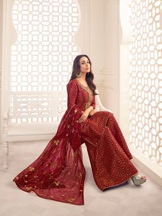 This Malaika Arora Maroon Zari Woven Yoke Design Embroidered Straight Kurta set features true craftsmanship in a luxurious silk blend design. Embellished with intricate Zari, this sharara is perfect for ethnic events and winter parties. Ready-to-wear, it features a round neck and three-quarter sleeves, with side slits for extra comfort. Grandeur and majestic artwork is attributed to this exquisite creation by Malaika Arora. TOP: Silk Blend(Brocade), TOP INNER: Cotton, BOTTOM: Silk Blend(Brocade) Semi-stitched Banarasi Silk Sharara With Dabka Work, Festive Long Lehenga With Dabka Work, Diwali Long Lehenga With Dabka Work, Diwali Dabka Work Long Lehenga, Festive Banarasi Silk Palazzo Set With Resham Embroidery, Unstitched Chinon Anarkali Set With Self Design, Long Sharara With Dabka Work For Navratri, Festive Resham Embroidered Long Lehenga, Festive Designer Semi-stitched Salwar Kameez