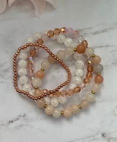 "Gorgeous bracelet stack made of four bracelets: 1. 8mm opal pink semi precious beads with gold spacers 2. 8mm crackle quartz stone crystal glass beads 3. 6mm czech faceted pink mix glass beads 4. 3mm rose gold metal beads The bracelets shown are approximately 7\" in length." Rose Gold Crystal Bracelet With Round Rose Quartz Beads, Rose Gold Rose Quartz Crystal Bracelet With Round Beads, Spiritual Rose Gold Beaded Bracelets, Handmade Rose Gold Crystal Bracelet With Round Beads, Handmade Rose Gold Beaded Bracelet With Round Beads, Handmade Rose Gold Beaded Bracelets, Handmade Rose Gold Beaded Bracelet, Rose Gold Beaded Bracelets With Gemstone Beads, Rose Gold Bracelets With Gemstone Round Beads