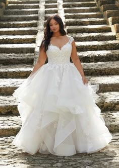 a woman in a wedding dress standing on some steps