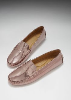 Hugs & Co. rose gold high gloss penny loafer driving shoes for women. Moccasin style driving loafers made with luxurious rose gold patent leather upper and lined with a soft leather for extra comfort. Made in Portugal 100% Patent Leather Upper featuring a 100% Leather Lining Rubber studded sole in black Elegant Pink Flats With Rubber Sole, Luxury Pink Leather Flats, Elegant Pink Loafers With Rubber Sole, Elegant Pink Loafers With Round Toe, Elegant Pink Slip-on Flats, Luxury Pink Loafers For Formal Occasions, Driving Loafers With Rubber Sole, Luxury Flat Heel Moccasins, Moccasins Style