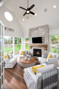 a living room filled with furniture and a flat screen tv mounted on the wall above a fire place