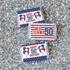 two red, white and blue birthday candy bar wrappers on top of silver glitter