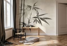 an empty room with a bamboo tree painted on the wall and a chair next to it