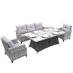 an outdoor dining set with grey wicker furniture and white cushions, including a glass top table