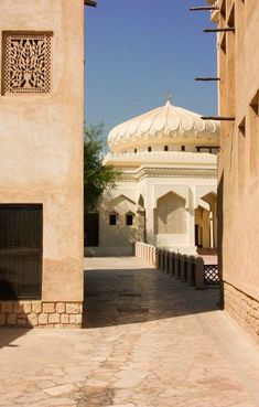 an archway leading to a building with a white dome