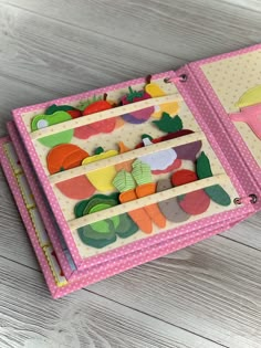 two pink binders with felt fruits and vegetables on them