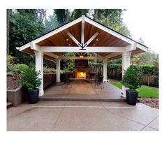 a covered patio with tables and chairs under a wooden roof over an open fire pit