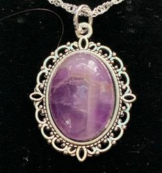 Very nice looking,.  Amethyst is one of the most famous and prominent crystals because of its beautiful coloration as well as its spiritual and literal meaning.  The spiritual meaning of Amethyst is groundedness, tranquility, and calm. The literal meaning of Amethyst is "not intoxicated".  To this ancient, wise culture, the Amethyst crystal was of the utmost importance, and the myth associated with it still lives on inside it to this day.  You can immediately feel peace of mind by simply looking at this brilliant crystal. In fact, its radiant purple and white colors have represented the sobriety of emotions and spirit throughout history.  It is also the traditional gift for a couple's 33rd wedding anniversary because 33 is the number of divine protection. Stone Size: 18x13 mm.   USPS First Spiritual Oval Cabochon Necklace, Spiritual Oval Cabochon Gemstone Necklaces, Mystical Healing Necklace With Cabochon, Purple Gemstone Oval Pendant Necklace, Purple Gemstone Necklace With Oval Pendant, Spiritual Purple Necklace With Large Stone, Oval Amethyst Necklace With Natural Stones, Spiritual Purple Necklace With Large Pendant, Purple Spiritual Necklace With Large Pendant