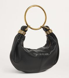 Find CHLOÉ Bracelet Top-handle Bag on Editorialist. The Chloé Bracelet bag is crafted from smooth leather and features a slouchy silhouette. It is suspended from a gold-tone ring handle, which gives the bag its name. The bag has a zip closure and is small in size. It can be worn on the shoulder or hand carried. Chloe Bracelet Bag, Chloe Mini Bag, Bracelet Bag, Tom Ford Clothing, Ring Handle, Gold Bag, Christmas Crackers, Festive Tables, Fine Watches