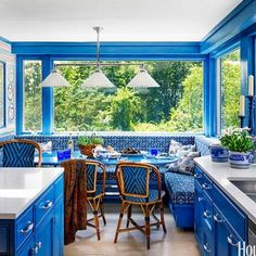 a kitchen with blue cabinets and white counter tops, along with an island in the middle