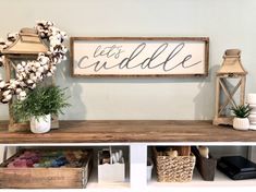 a wooden sign that says let's cuddle on it next to other items