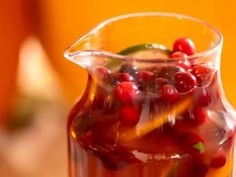 a pitcher filled with cranberry sauce on top of a table