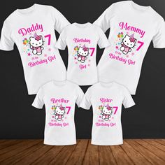 three white shirts with hello kitty on them and the number seven for each child's birthday