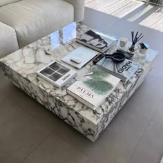 a marble coffee table with books and magazines on it