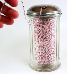 a spool of red and white twine in a jar