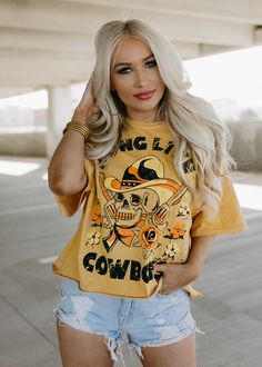 Long Live Cowboys Skull OVERSIZED 80's throwback distressed Cropped T- shirt available in faded mustard This Crop Jersey Tee slides right into streetwear style for Summer and Winter.. With oversized sleeves and a relaxed body, this on-trend tee drops a little lower in the back for an effortlessly cool feel. Fabricated from ultra-soft, lightweight Airlume cotton that's fit to flatter, this looser crop features a finished hem and neck binding.Features: Finished hem. Oversized sleeves. Neck binding Distressed Hip Hop Crew Neck Top, Hip Hop Distressed Crew Neck Top, Trendy Oversized Skull Print Tops, Trendy Oversized Tops With Skull Print, Skull Print Tops For Spring Streetwear, Oversized Hip Hop Tops For Halloween, Hip Hop Distressed Cotton Top, Casual Yellow Top For Halloween, Acid Wash T-shirt For Fall Streetwear