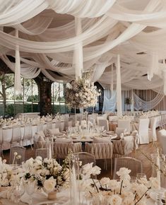 a banquet hall with tables and chairs covered in white draping