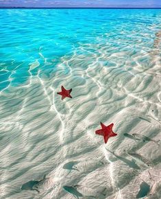 two red stars floating on top of a sandy beach