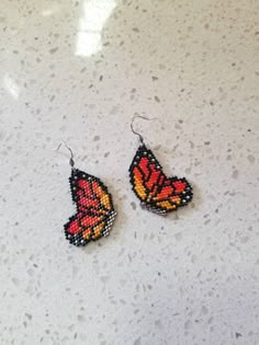 pair of beaded butterfly earrings on white surface