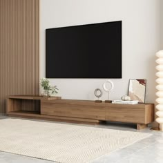 a large flat screen tv mounted to the side of a wooden entertainment center in a living room