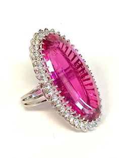 Platinum Pink Tourmaline & Diamond Cocktail Ring DescriptionPlatinum Ring; 1 Oval Pink Tourmaline 31.11 Carat; 37 Round Brilliant Cut Diamonds 1.48 Carat Total Weight, SI-1, I-J; Finger Size 5 1/2; 19.7 Grams. #BarbieRing#Barbie#BarbiePink Payment All payments must be made through PayPal, NO EXCEPTIONS. We cannot accept payment plans. We do not offer Layaway. Shipping We ship via USPS Registered Mail, Return Receipt in order to provide tracking and insured delivery, which usually takes 5-7 days Oval Ruby Ring For Party, Oval Ruby Ring For Parties, Party Ruby Gemstone Rings, Oval Gemstone Party Rings, Oval Gemstone Rings For Party, Ruby Party Ring, Formal Pink Rings With Polished Finish, Oval Fine Jewelry Rings For Party, Dazzling Oval Rings For Party