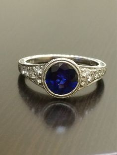 DeKara Designs Collection An Art Deco Platinum Ceylon Blue Sapphire breathtaking ring that must be seen in person to be appreciated.  Metal- 90% Platinum, 10% Iridium.Stones- 1 Round Ceylon Blue Sapphire, 1.83 Carats.  10 Round Diamonds, G color VS1 clarity, 0.36 Carats.  The craftsmanship on this ring is impeccable, and will look extraordinary on a true art lovers finger.  You will wear this ring with great joy, and love.  You will keep glancing at it because it will distract you so much!  Plea Dazzling Round Sapphire Wedding Ring, Classic Sapphire Diamond Promise Ring, Exquisite Round Cut Sapphire Wedding Ring, Exquisite Sapphire Ring For Wedding, Classic Gia Certified Sapphire Ring, Dazzling Diamond Cut Sapphire Wedding Ring, Exquisite Sapphire Wedding Ring With Accent Stones, Dazzling Diamond Cut Sapphire Ring For Wedding, Dazzling Sapphire Wedding Ring With Accent Stones