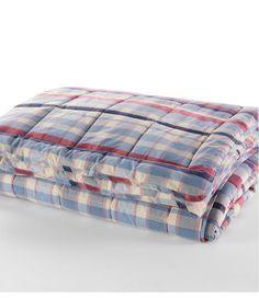 the blue and red plaid blanket is folded on top of each other, with one side rolled up