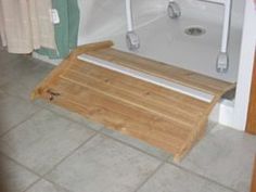 a bath tub with a wooden step on the floor