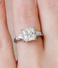 Our gorgeous collection of moissanite engagement rings includes the princess & baguettes 3-stone diamond ring. Our princess-cut diamonds are known for their square shape and are completely symmetrical to maximum brilliance. Accent moissanite features a three-stone style with classic tapered baguettes held in a classic bar setting on either side of the center stone. ✤Material Details✤ ⇒Base Metal: Sterling Silver ⇒Metal Purity: 925 ⇒Stamping: S925 ⇒Plating Option: White Gold, Yellow Gold, Rose Go Three Stone Princess Engagement Rings, Wedding Ring Square, White Gold Engagement Rings Princess Cut, Ring Square Diamond, 3 Stone Diamond Ring, Bar Setting, Baguette Engagement Ring, Princess Cut Moissanite, Ring Square