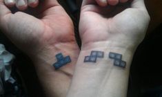 two people with matching tattoos on their wrists, both showing the same cross tattoo