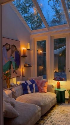 a living room filled with lots of furniture under a skylight next to a window