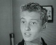 black and white photograph of a young man with curly hair