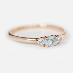 three stone engagement ring in rose gold with blue topazte and white diamond accents