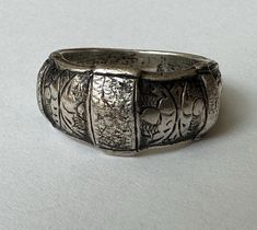 another piece that i've had sitting here with me for a long time because i adore it... a sterling ring from Siam, likely in the 1940's.  it has wondrous texture and hand engraving and a bit of a dome.  it has nice weight and is marked Siam Sterling.  it's also marked 7, for the size, but due to its width i prefer it as a 6.75.  it has some wear on the inner band but mostly very nice condition. size:  6.75-7 height of face;  3/8" width of inner band:  between 2 and 3/16" weight:  9.6g Vintage Metal Cuff Bracelet With Filigree, Ornate Handmade Antique Silver Cuff Bracelet, Vintage Silver Hand Tooled Cuff Bracelet, Vintage Silver Hand-tooled Belt, Here With Me, Vintage Silver Hand-tooled Cuff Bracelet, Metal Work, Hand Engraving, Sterling Ring