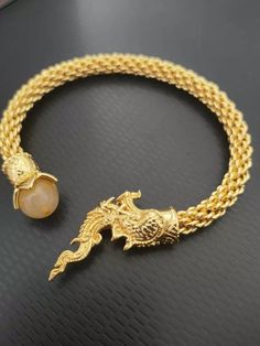 Naga Snake Bracelet Thai Amulet Brass Coated Magic Serpent Money Rich Good Charm Guru Monk create this amulet as love charm amulet.  Carry out will make people fascinated with you. Materials = Mixed Colour = Gold Quantity : 1 pcs Length :20 cm.  Inner diameter: 6 cm. (Can be flexible in and out) Shipping Information & Return Policy. Handling time 2-3 business days FREE Shipping handling to WORLDWIDE via THAILAND POST with TRACKING NUMBER, The packet will take about 14-20 business days.   *100% S Symbolic Gold Jewelry For Blessing, Spiritual Style Chain Bracelet, Spiritual Pendant Bracelets For Gifts, Spiritual Good Luck Jewelry Bracelet, Gold Spiritual Bracelets, Gold Spiritual Charm Bracelet, Spiritual Round Gold Bracelets, Spiritual Ceremonial Bracelet Jewelry, Amulet Style Bracelet Jewelry Gift