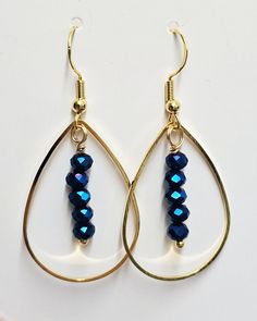 Unique handmade gold teardrop earrings with blue glass faceted beads. Earrings are very shiny. The length of earrings is approximately 43-44mm (whole length including the ear wire/hook), approximately 22mm wide. Made of high quality gold plated stainless steel, gold plated copper wire and glass faceted 4mm beads. Ear wires/hooks are made from gold plated stainless steel. Silicone earrings stoppers are included. Please note earrings can be slightly different to the photo as each jewellery piece i Gold Teardrop Hoop Earrings With Dangling Beads, Gold Teardrop Earrings With Round Beads For Gifts, Gold Teardrop Beaded Hoop Earrings, Gold Faceted Teardrop Hoop Earrings, Gift Faceted Beads Dangle Teardrop Earrings, Gift Dangle Teardrop Earrings With Faceted Beads, Gold Teardrop Earrings With Dangling Beads, Gift Teardrop Dangle Earrings With Faceted Beads, Blue Teardrop Wire Wrapped Crystal Earrings