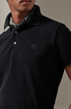 Mercerized for enhanced durability and color retention, this cotton-piqué polo is refined with mother-of-pearl buttons and an embroidered logo. 28 1/2" length (size medium) Button half-placket Spread collar Short sleeves 100% cotton Machine wash, dry flat Made in Italy Designer Clothing Designer Black Polo Shirt With Collared Neckline, Black Designer Polo Shirt With Collared Neckline, Designer Top With Embroidered Logo And Collared Neckline, Designer Tops With Embroidered Logo, Collared Polo Shirt With Embroidered Logo For Work, Collared Polo Shirt With Embroidered Logo, Luxury Short Sleeve Polo Shirt For Work, Designer Black Polo Shirt With Embroidered Logo, Luxury Formal Polo Shirt With Collared Neckline