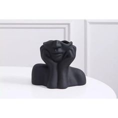 a black sculpture sitting on top of a white table