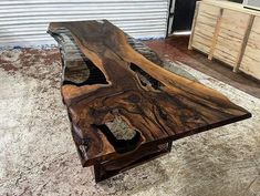 a wooden table sitting on top of a floor next to a metal door and window