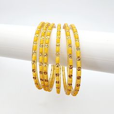 Add a touch of elegance to your ensemble with Priya Glass Bangles. The pale orange/yellow and muted gold colors exude a subtle sophistication. Handcrafted with precision and quality, these bangles are a must-have addition to your jewelry collection. *Sold as a six-piece set.*To prevent any potential damage, please put on each glass bangle individually. For a snug fit, we suggest sizing up from your usual bangle size. Adjustable Yellow Round Bangle, Yellow Bracelets For Party And Festivals, Festive Yellow Round Jewelry, Adjustable Yellow Bangle For Festivals, Festive Yellow Bangle Jewelry, Festive Yellow Bangle Bracelet, Orange Bangle For Festivals, Yellow Bracelet Jewelry For Festivals, Adjustable Yellow Bangle For Festive Occasions