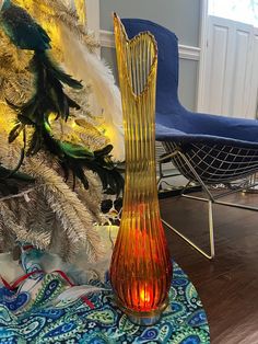 a glass vase sitting next to a christmas tree